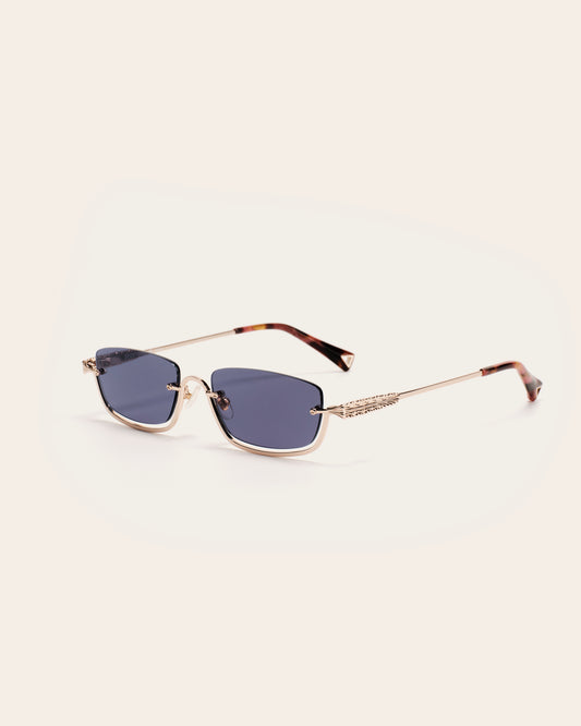 Sunglasses with gold frame and blue lenses on a light beige background